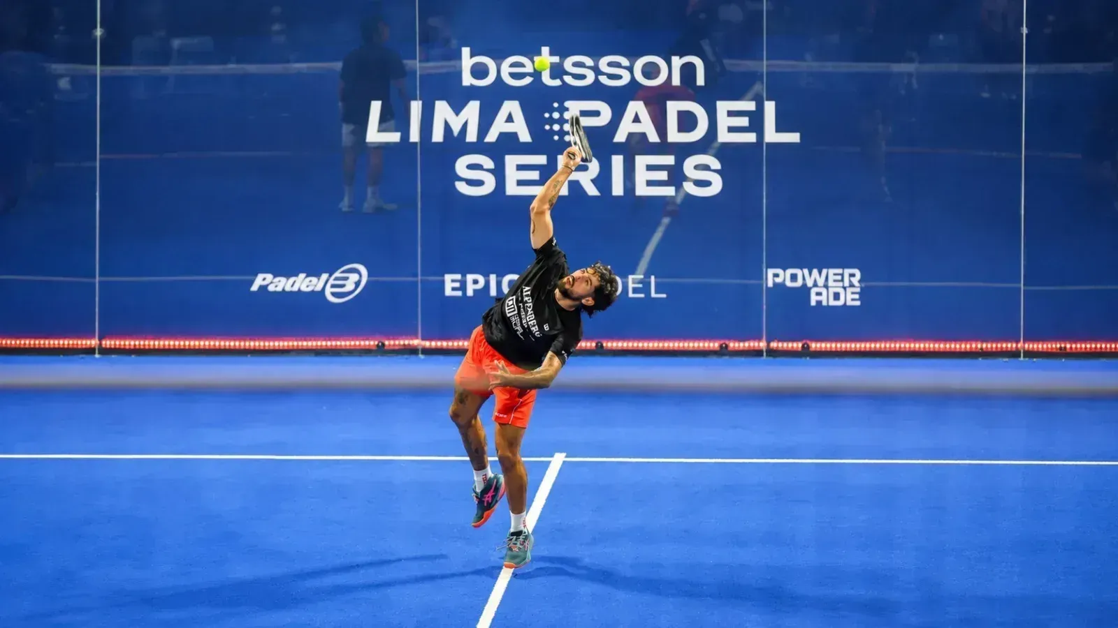 Jugador de pádel en pleno remate sobre una cancha azul, con el letrero del Betsson Lima Pádel Series al fondo.